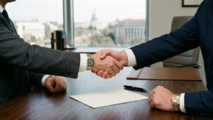 Handshake across a desk over a document, illustrating business purchase and sale disputes